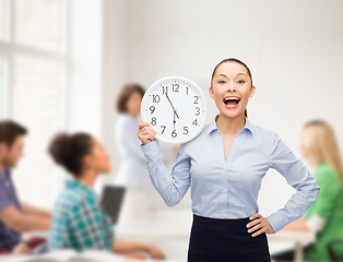 Image showing attractive teacher with wall clock