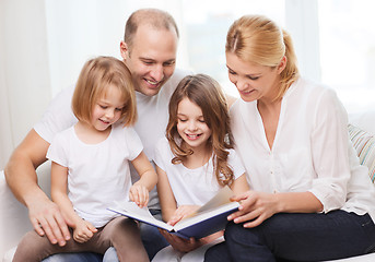 Image showing smiling family and two little girls with book