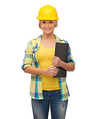 Image showing smiling woman in helmet with clipboard