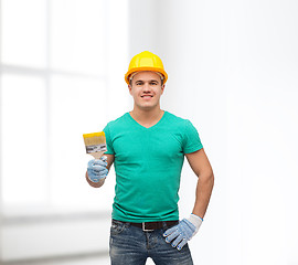 Image showing smiling manual worker in helmet with paintbrush