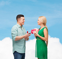 Image showing smiling couple with flower bouquet and ring