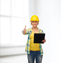 Image showing smiling woman in helmet with clipboard