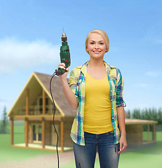 Image showing smiling woman with drill machine