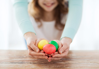 Image showing close up of girl and mother holding colored eggs