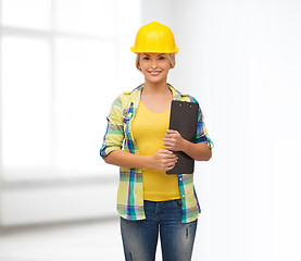 Image showing smiling woman in helmet with clipboard