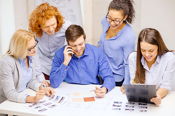 Image showing creative team with papers and clipboard at office