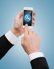 Image showing businessman touching screen of smartphone