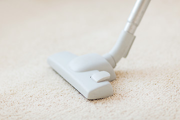 Image showing close up of male hoovering carpet