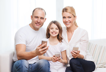 Image showing parents and little girl with smartphones at home