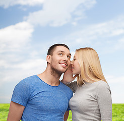 Image showing smiling girlfriend telling boyfriend secret