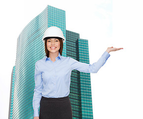 Image showing businesswoman in helmet holding something on palm