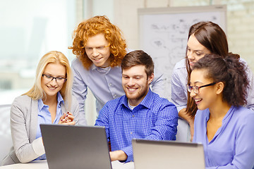 Image showing smiling team with laptop computers in office