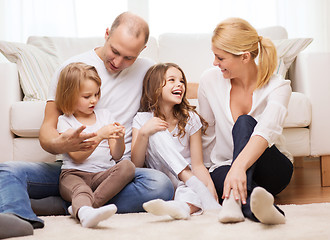 Image showing parents and two girls sitting on floor at home