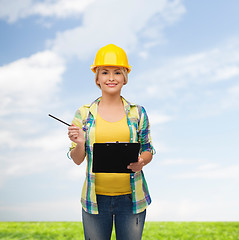 Image showing smiling woman in helmet with clipboard