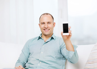 Image showing smiling man with smartphone at home