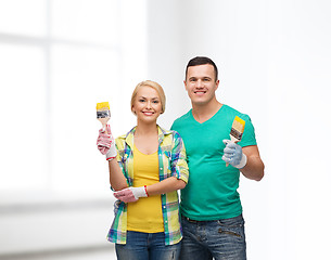 Image showing smiling couple with paintbrush