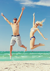 Image showing couple jumping on the beach