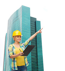 Image showing smiling woman in helmet with clipboard