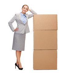 Image showing smiling businesswoman with cardboard boxes