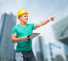 Image showing smiling man in helmet with clipboard