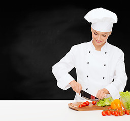 Image showing smiling female chef chopping vagetables