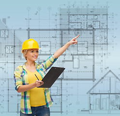 Image showing smiling woman in helmet with clipboard