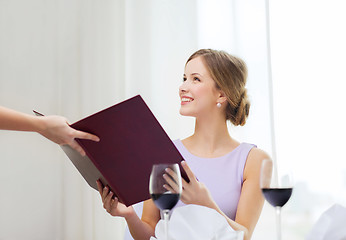 Image showing smiling woman recieving menu from waiter