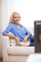 Image showing young girl with popcorn watching movie at home