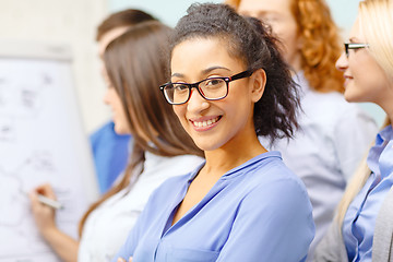 Image showing smiling businesswoman with team team on the back