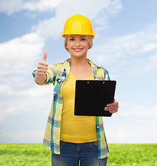 Image showing smiling woman in helmet with clipboard