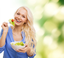 Image showing smiling young woman with green salad