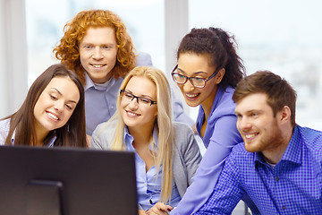 Image showing smiling business team looking at computer monitor