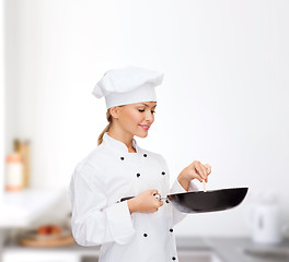 Image showing smiling female chef with pan and spoon