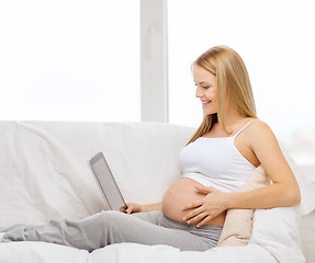 Image showing smiling pregnant woman with tablet pc computer