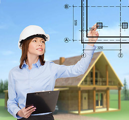 Image showing smiling businesswoman in helmet with clipboard