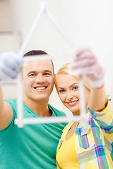 Image showing smiling couple with house from measuring tape