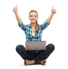 Image showing smiling woman with laptop and showing thumbs up