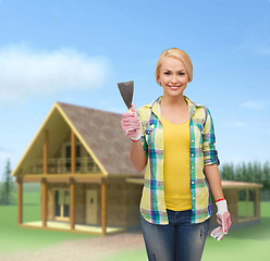 Image showing smiling female worker in gloves with spatula