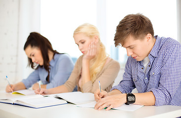 Image showing tired students with notebooks at school