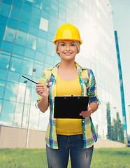 Image showing smiling woman in helmet with clipboard