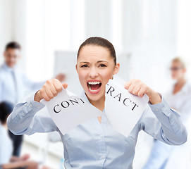 Image showing serious businesswoman tearing contract