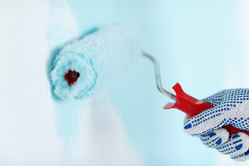 Image showing close up of male in gloves painting wall