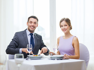 Image showing smiling couple eating appetizers at restaurant