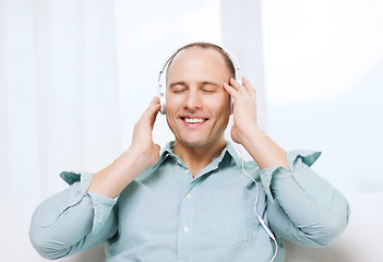 Image showing smiling man with headphones listening to music