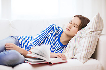 Image showing smiling teenage girl sleeping on sofa at home