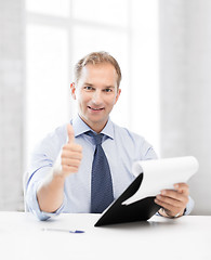 Image showing businessman with papers showing thumbs up