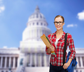 Image showing female student in eyeglasses with bag and folders