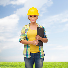 Image showing smiling woman in helmet with clipboard