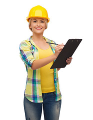 Image showing smiling woman in helmet with clipboard