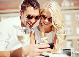 Image showing couple looking at smartphone in cafe